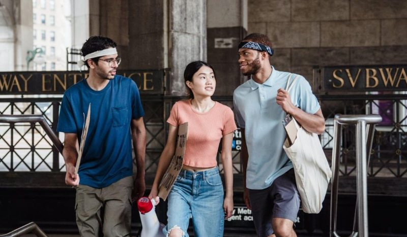 people-holding-posters-while-walking-on-the-street